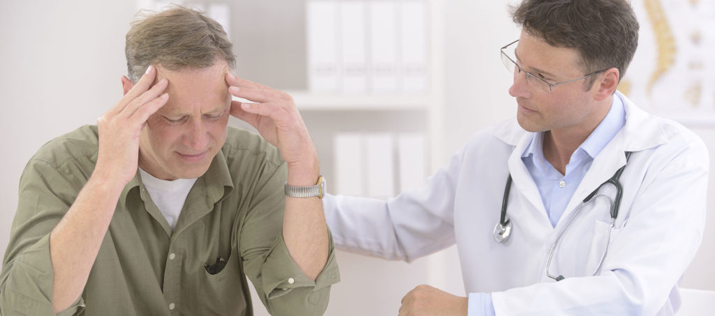 A physician consoles his patient who is stressed out.